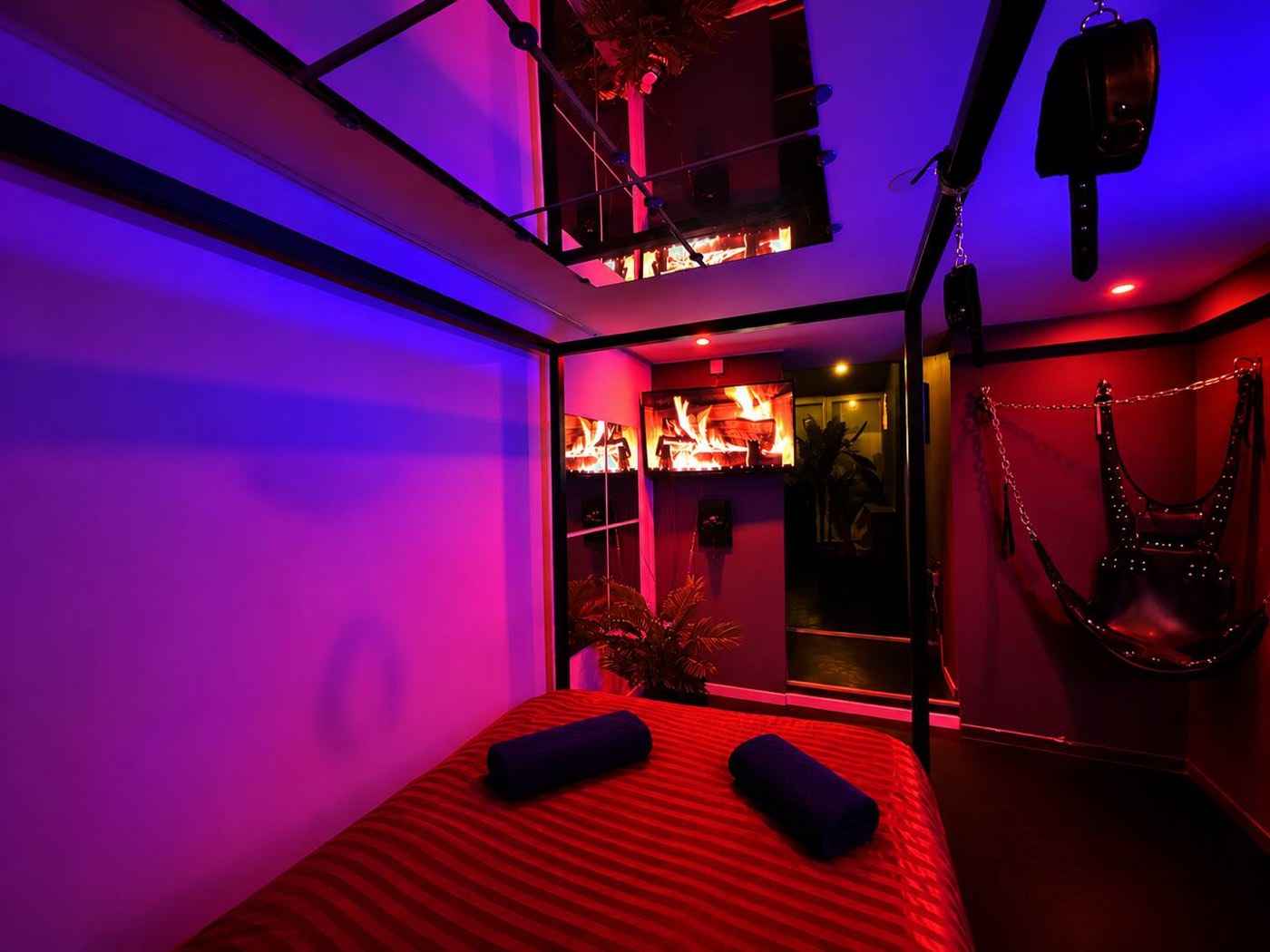 Lit sous lumière rouge et violette, dans la Suite Éros à Souppes-sur-Loing